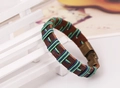 Detalle de pulsera de cuero marrón tejida a mano con cordones azul-verde y cierre de bronce - Cordón Azul y Verde Oscuro