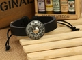 Nahaufnahme von schwarzem Lederarmband mit gravierter Metallschnalle auf Holzgrund - Schwarz