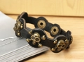 Detailaufnahme von schwarzem Punk-Lederarmband mit Vintage-Totenkopf-Nieten aus Bronze - Schwarz