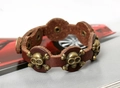 Nahaufnahme von Punk-Totenkopf-Nieten auf dunkelbraunem Lederarmband mit Bronze - Braun