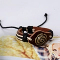Gros plan détaillé du bracelet en cuir marron fait main avec rose en bronze et corde tressée - Rose