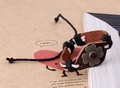 Gros plan d'un bracelet en cuir vintage avec une fleur en bronze et cordons tressés réglables - Tournesol