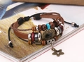 Detail view of multi-layer leather bracelet featuring woven ropes and star pendant - Brown