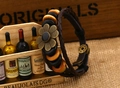 Detailed macro of vintage woven leather bracelet with wooden beads and sunflower metal charm - Black Flower