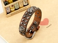 Makroaufnahme des braunen Leder-Punk-Armbands mit Metallnieten und Schnallenverschluss - Braun
