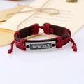 Dettaglio del bracciale in pelle intrecciata con lacci regolabili e piastra in metallo - Rosso Scuro