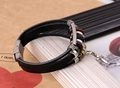 Close-up of multilayer leather bracelet featuring metal cross pendant and wooden beads - Black