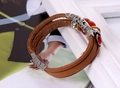 Detail of multi-layer brown leather bracelet with silver floral tubes and red beads - Tan