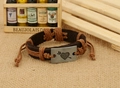 Detail of vintage leather bracelet with arrow heart metal plate and braided hemp ropes - Tan
