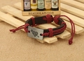 Detail of vintage braided leather bracelet with Cupid arrow metal charm on linen backdrop - Dark Red