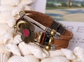Dettaglio di bracciale vintage in pelle multistrato con fiore in bronzo e perle in legno - Cuoio
