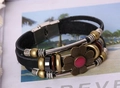 Dettaglio del bracciale in pelle multistrato retrò con perline in bronzo e ciondolo fiore - Nero