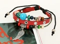 Detail eines mehrlagigen Lederarmbands mit Perlen und silbernem Federanhänger in Rot - Rot