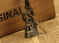 Détail macro des pendentifs Tour Eiffel et croix sur collier en cuir vintage - Bronze Antique