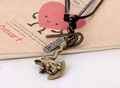 Dettaglio di ciondoli vintage in bronzo ad ascia e croce su collana in pelle nera - Ascia
