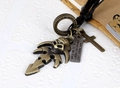 Detail van vintage bronzen schedelzwaard hanger aan zwart gevlochten lederen koord - Antiek Brons