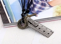 Close-up of vintage multi-pendant leather necklace with bronze cross and ruler charms - Antique Silver