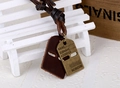 Detailed close-up of retro leather pendant with engraved bronze alloy identity tags - Bronze