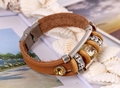 Detail eines mehrlagigen braunen Lederarmbands mit funkelnden Kristallen und Magnetverschluss - Hellbraun