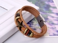 Macro detail of vintage brown leather bracelet with star charm and stainless steel clasp - Tan