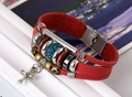 Macro detail of multi-layer red leather bracelet with cross charm and blue beads - Red