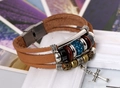 Detail of vintage multilayer leather bracelet with cross pendant and blue rhinestone bead - Tan