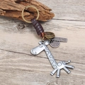 Retro Giraffen Schlüsselanhänger mit braunem Leder und Bronzeanhängern auf Holzgrund - Antiksilber