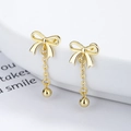 Elegant gold bow earrings with dainty chain and sphere drop on a white display pedestal - 925 Silver / Gold