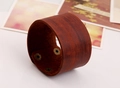 Makro-Detail eines braunen Lederarmbands mit drei Druckknöpfen aus Bronze-Metall - Braun
