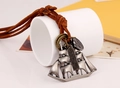 Macro detail of retro sailboat pendant with engraved plate on brown leather cord - Antique Silver