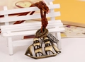 Detail of vintage bronze sailboat pendant and engraved tag on dark leather cord - Bronze