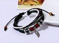 Makro-Detail von mehrlagigem Lederarmband mit Vintage-Blattanhänger und Holzperlen-Deko - Schwarz