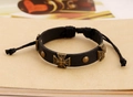 Makroaufnahme des schwarzen Lederarmbands mit Vintage-Kreuz aus Legierung und Nieten - Schwarz
