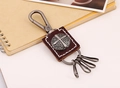 Dettaglio portachiavi vintage in pelle marrone con croce a rilievo e anelli metallici - Marrone