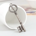 Vintage antique silver lightning key alloy pendant displayed on a white ceramic cup - Antique Silver
