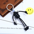 Handmade woven leather keychain featuring a ceramic bead and silver metallic accents - Black