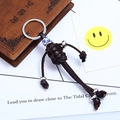 Handmade woven leather keychain with vintage ceramic bead and metallic accents - Brown