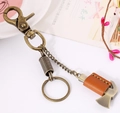 Llavero vintage de bronce con colgante de hacha miniatura y cuero marrón cosido - Bronce