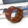 Vintage-Punk-Lederarmband mit goldenen Nieten und geflochtener Kordel auf Hintergrund - Braun