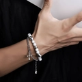 Bracciale a doppio strato in argento con croce e perline bianche indossato - Bracciale a Doppio Strato con Croce / Argento