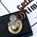 Vue macro de pendentifs vintage en bronze et cordon en cuir marron sur boîte à bijoux - Chapeau