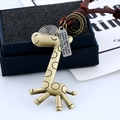 Détail d'un pendentif girafe vintage en bronze avec cordon en cuir et plaque métallique - Girafe