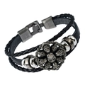 Close-up of multilayer braided leather bracelet with vintage skull metal charms - Skull
