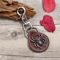 Retro punk leather keychain with a metallic spider charm on rustic wood background - Dark Brown