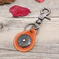 Portachiavi retrò in pelle arancione con rilievo floreale in metallo e anello in bronzo - Cuoio