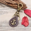 Vintage bronze anchor keychain with dark brown leather drop on natural wood background - Dark Brown