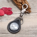 Retro punk style leather keychain with metal star pendant on rustic wood background - Black