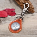 Retro brown leather keychain with a silver star emblem on a rustic wood background - Tan