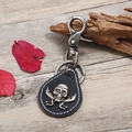 Portachiavi punk in pelle con teschio in argento antico su sfondo in legno naturale - Nero