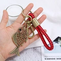 Detailed view of hollow fish pendant with bronze finish and red-black braided cord handle - Fish Style (CY045)